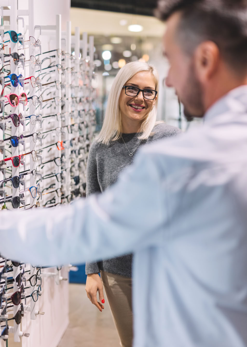 Person Holding Wine Glass Near Clear Shot Glasses